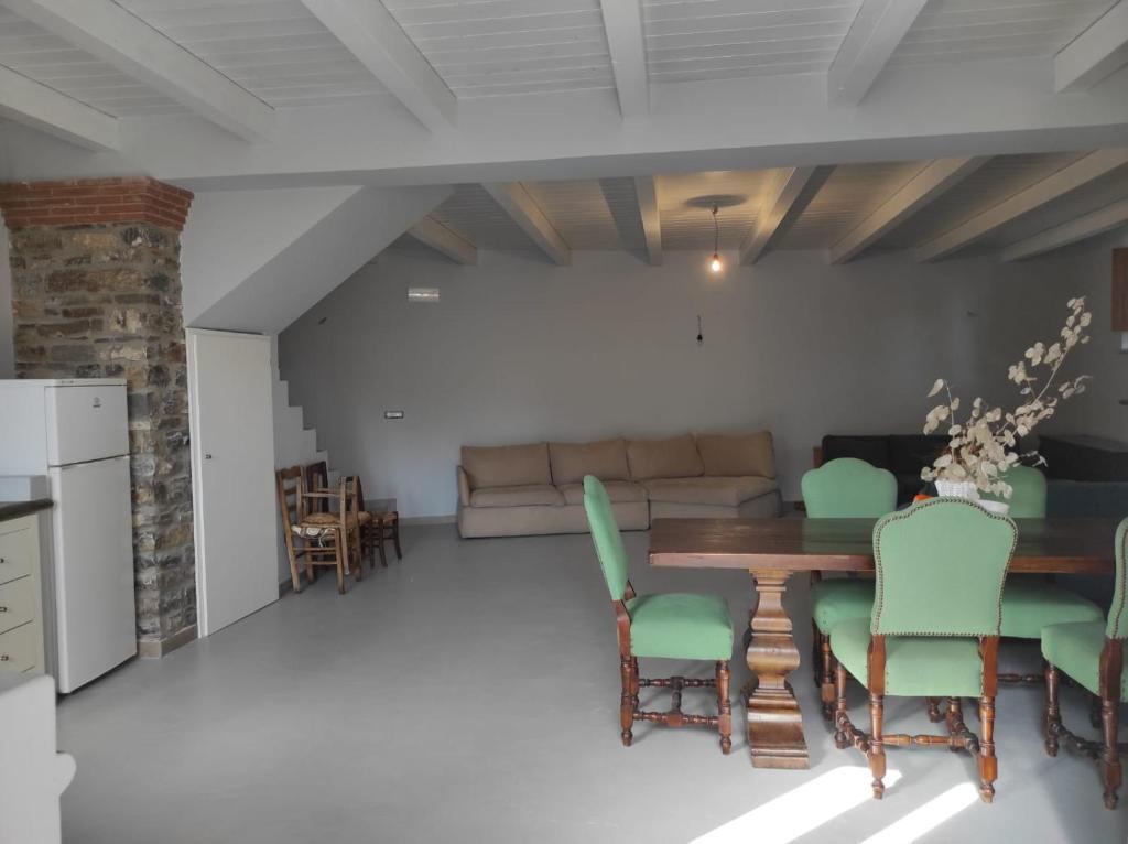 uma sala de estar com uma mesa de madeira e cadeiras verdes em Fantastica casa ai piedi del Monte Pollino em San Lorenzo Bellizzi