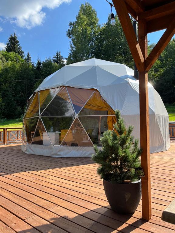 een grote tent op een terras met een potplant bij Epic House in Międzylesie