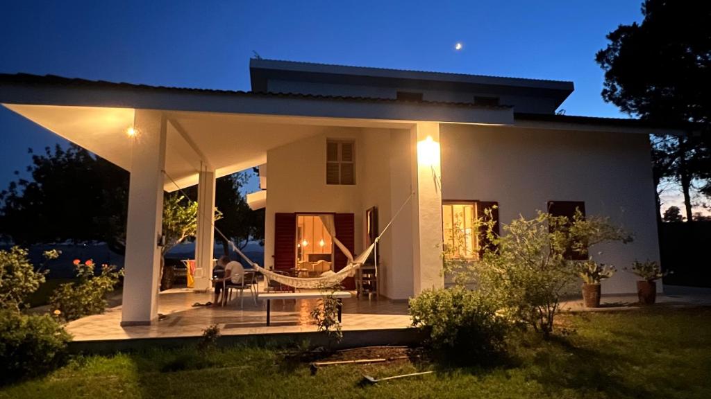 a white house with a porch at night at Villa CAPOROTONDO in Pisticci