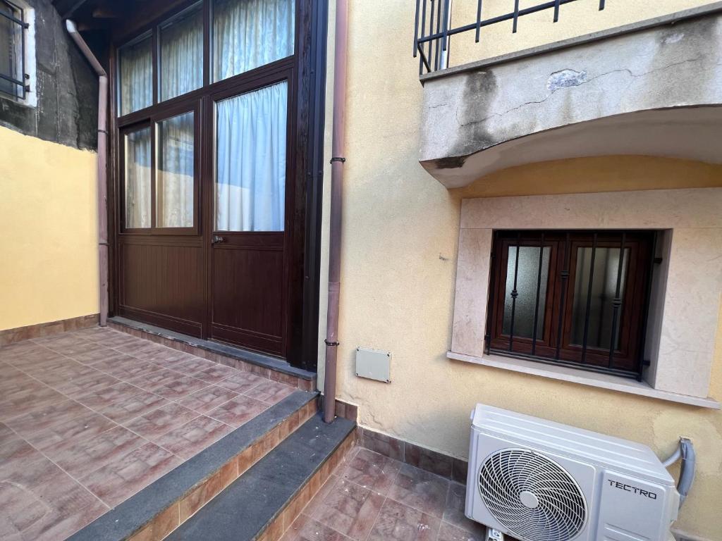 - une porte d'un immeuble avec un ventilateur à côté dans l'établissement Esclusivo Cortile Duca D'Aosta ai piedi dell'ETNA, à Viagrande