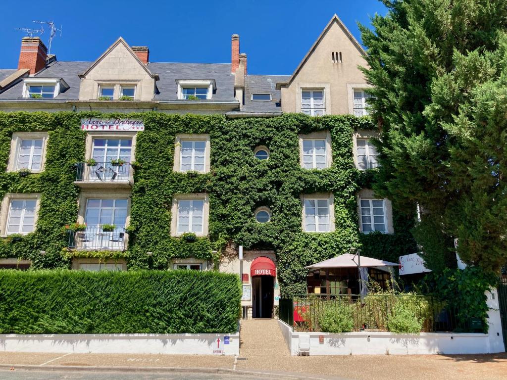 a building covered in green ivy at Hotel Anne De Bretagne BLOIS in Blois