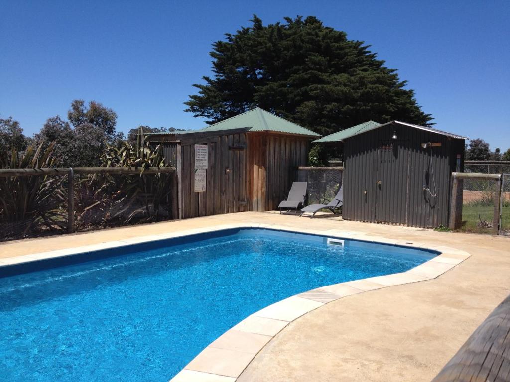 a swimming pool in a backyard with a wooden fence at Neerim Country Cottages in Neerim South