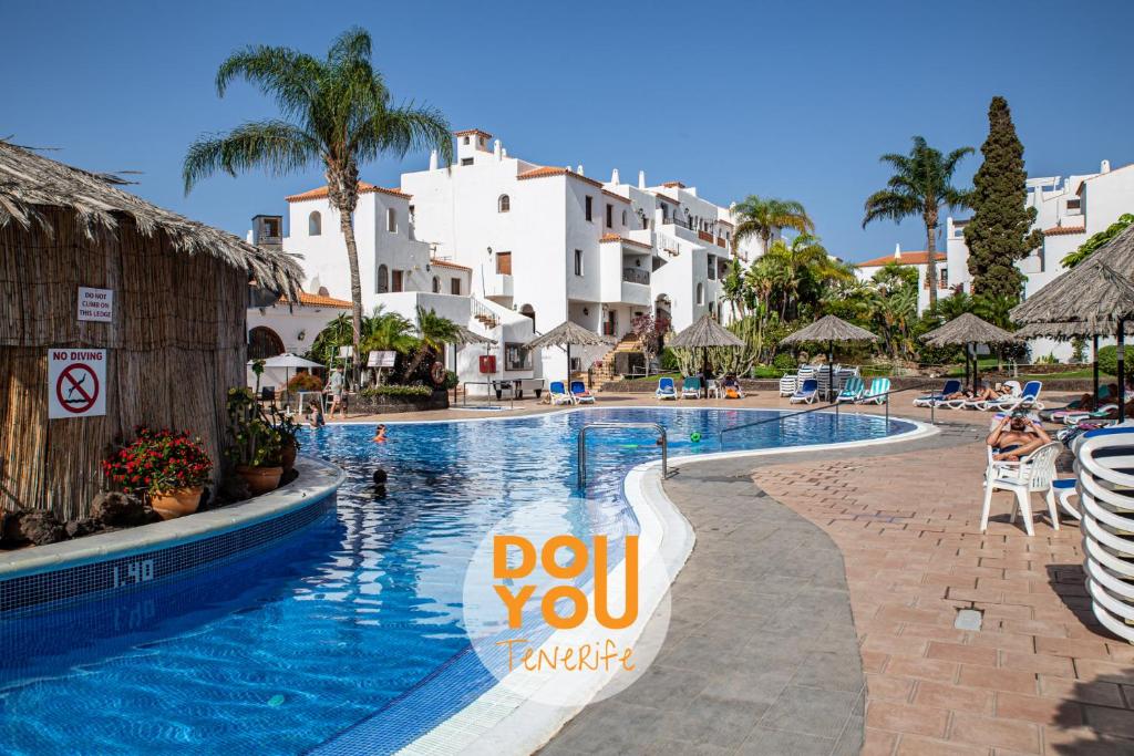 une piscine dans un complexe avec un panneau indiquant que vous visez dans l'établissement Apartment Fairways Club, à San Miguel de Abona