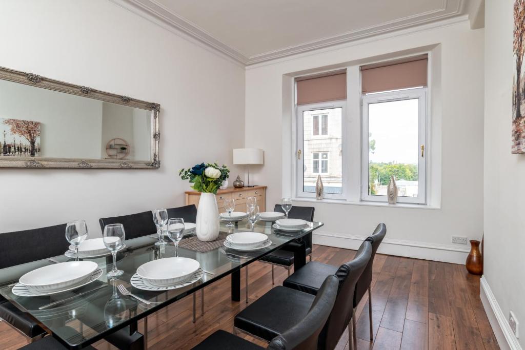 a dining room with a table and chairs and a mirror at Spacious 5-Bedroom Townhouse in the West-End in Aberdeen