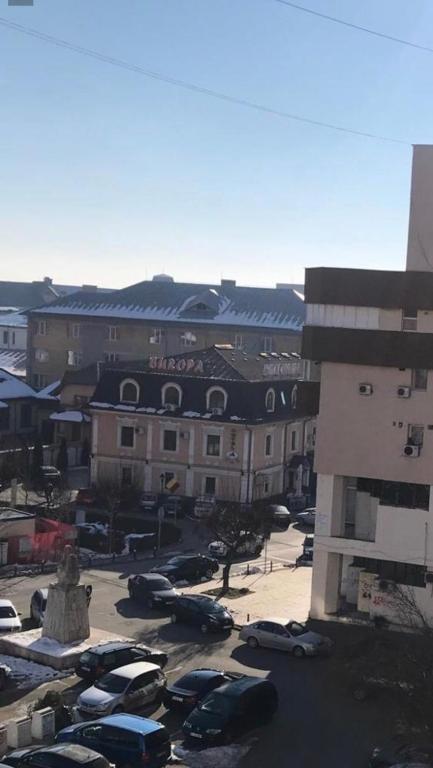 a parking lot with cars parked in front of a building at Garsoniera lux centru pietonal Tîrgu - Jiu in Târgu Jiu