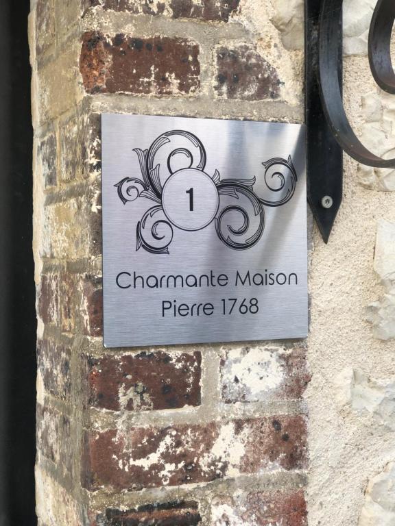a sign on the side of a brick wall at Charmante Maison Pierres 1768 in Polisy