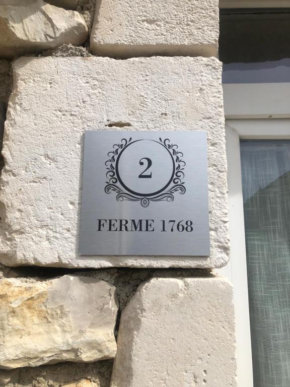 a sign on the side of a stone building at Charmante Maison Pierres 1768 in Polisy