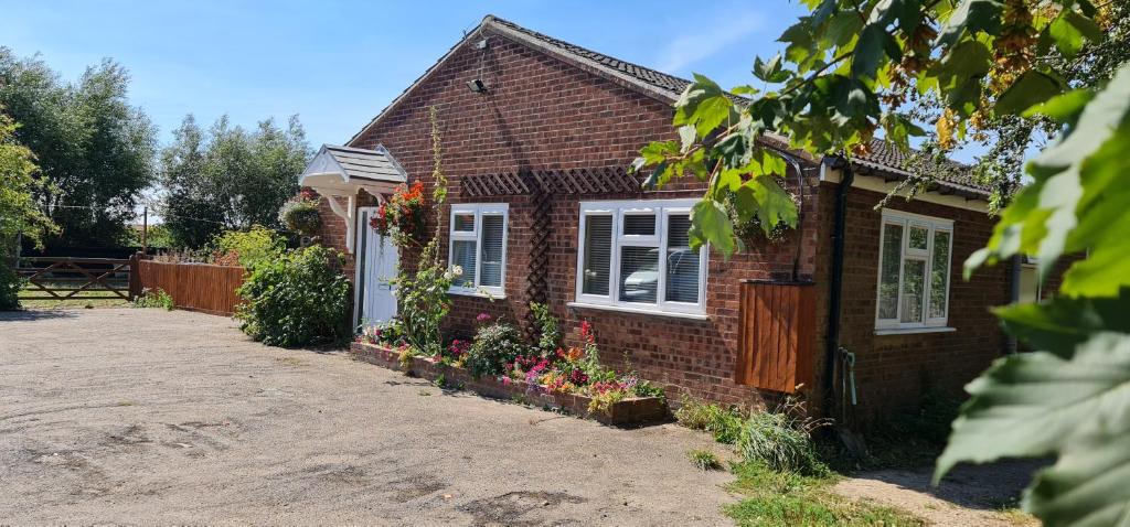 une maison en briques avec des fleurs devant elle dans l'établissement Sherwood Bungalow 3 Bedroom Entire Property, à Boston