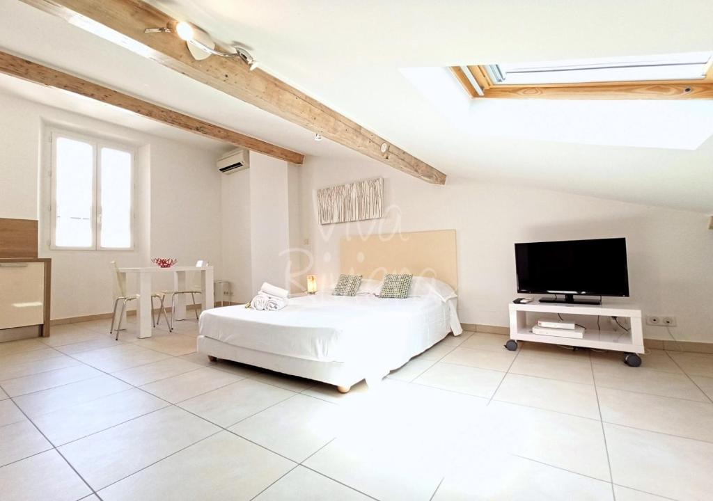 biała sypialnia z łóżkiem i telewizorem z płaskim ekranem w obiekcie Studio Eco-Friendly Commandant André w Cannes
