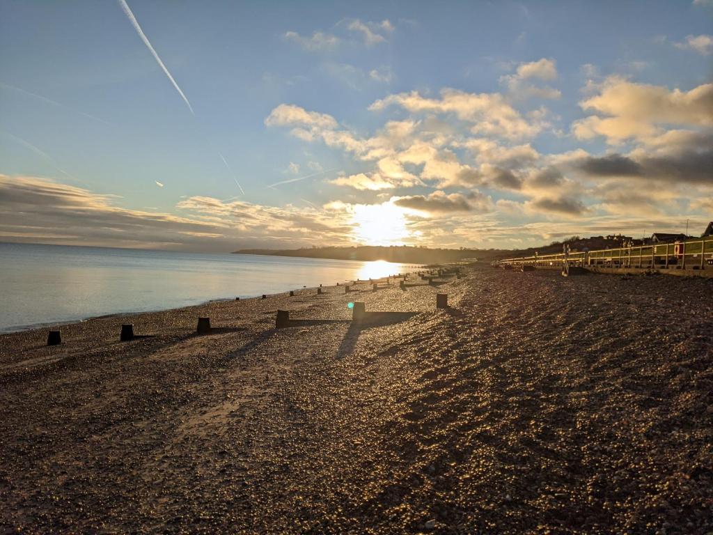 a sandy beach with the sun setting over the water at Banks Bed & Continental Breakfast in Minster