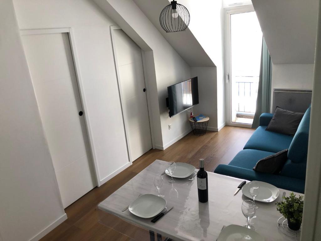 a living room with a table and a blue couch at Appart 6 pers rénové en plein cœur de Cauterets in Cauterets
