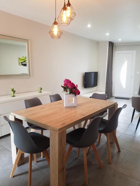 Un comedor con mesa y sillas de madera. en Le Plaisance, en Ourville-en-Caux