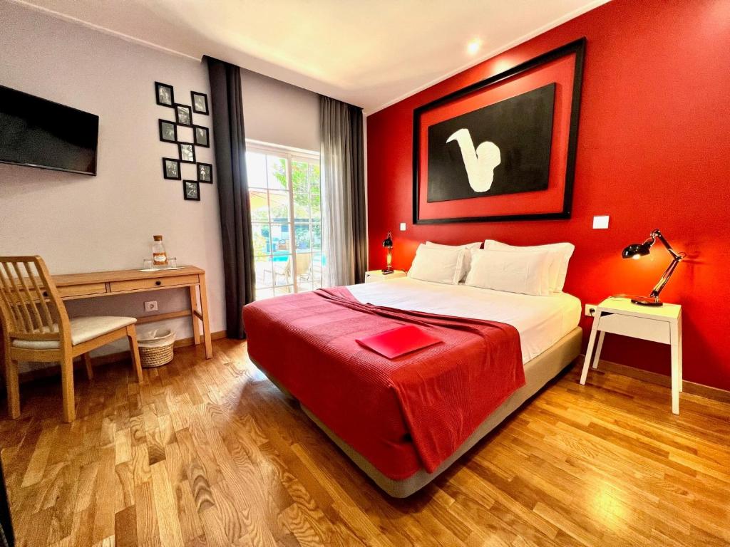 a bedroom with red walls and a bed and a desk at Buganvilias Do Meco Guest house in Sesimbra