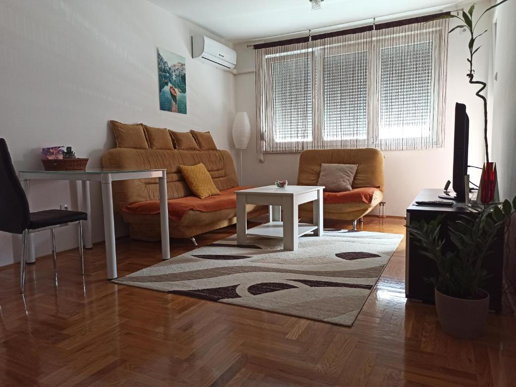 ein Wohnzimmer mit einem Sofa und einem Tisch in der Unterkunft BK Apartment, Istocno Sarajevo, Lukavica in Lukavica