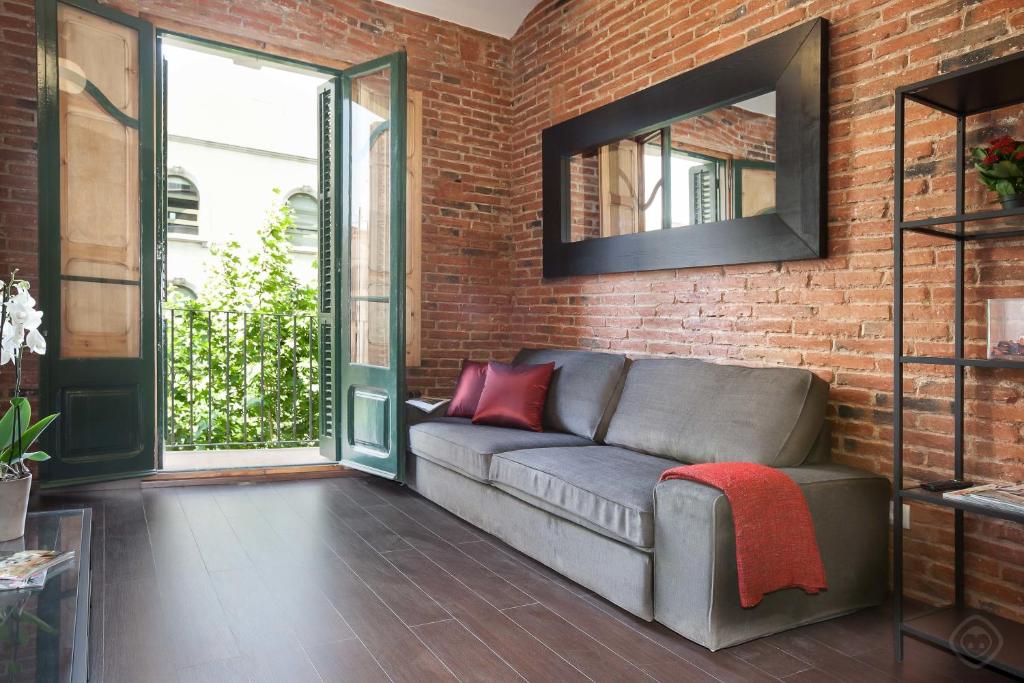 a living room with a couch and a brick wall at Eixample Sagrada Familia Apartments II in Barcelona