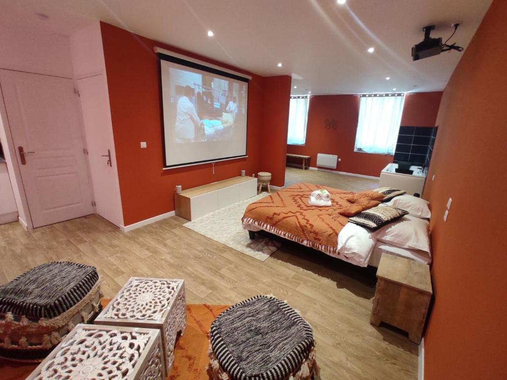 - une chambre avec un lit et un grand écran dans l'établissement NG SuiteHome - Lille I Roubaix Centre I Coq Français - Balnéo - Netflix - Wifi, à Roubaix