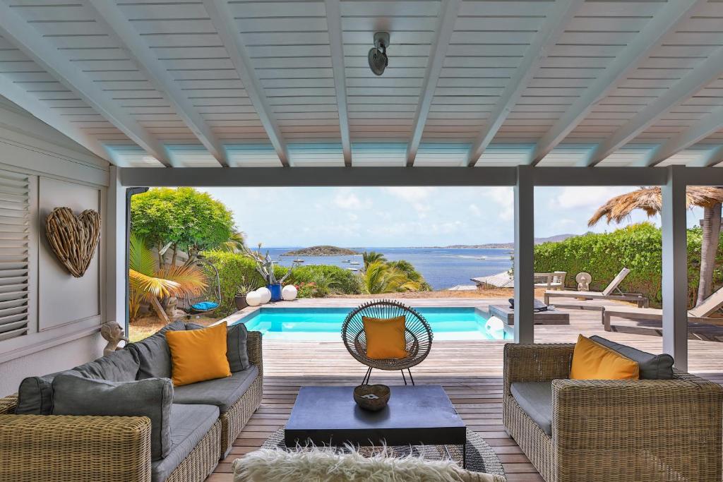 a living room with a view of a swimming pool at LIFE IS GOOD IN CUL DE SAC in Saint Martin