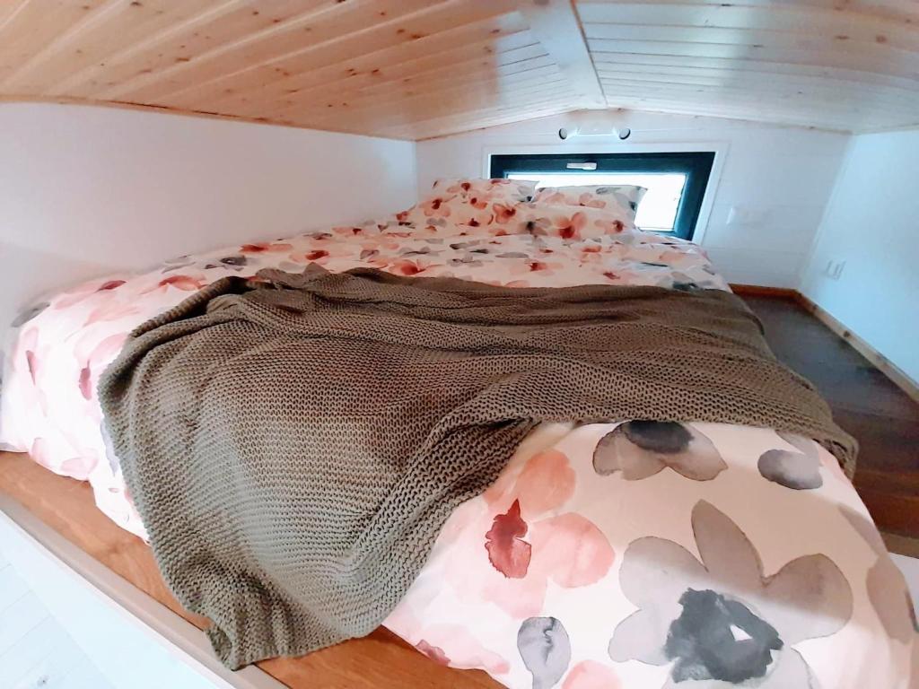 a bed with a blanket on it in a room at Togethernest Glamping in Mătişeşti