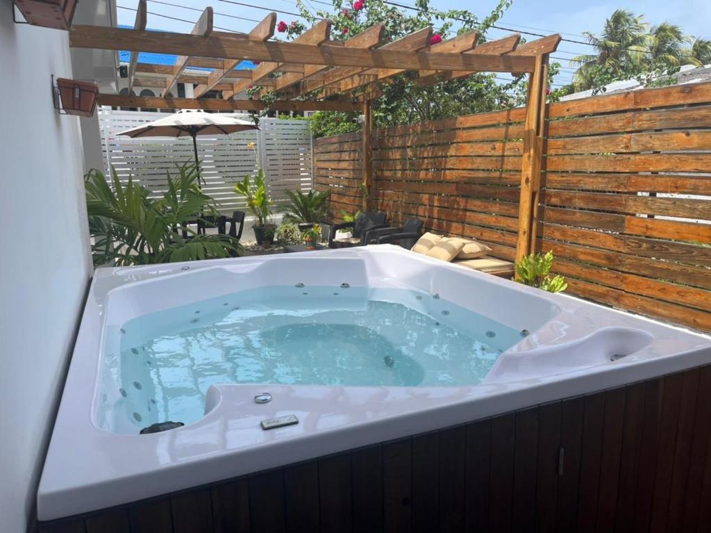 un jacuzzi en un patio trasero con una valla de madera en ATLANTIS CASA BOUTIQUE , con jacuzzi cerca de la playa en San Andrés