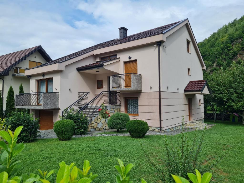 ein großes weißes Haus mit einem Hof in der Unterkunft Apartmani Minjević in Bijelo Polje