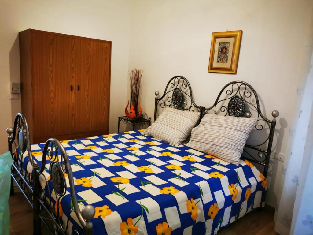 een slaapkamer met een bed met een blauw en geel dekbed bij Casa Mastio in Galtellì