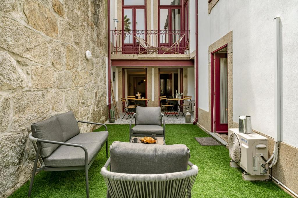 un patio con 2 sillas y una mesa sobre hierba en Private Garden in Porto City Center, en Oporto