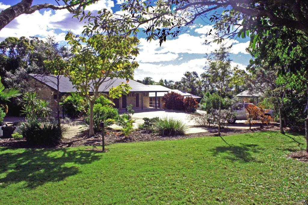 a house with a lawn in front of it at Emeraldene Inn & Eco-Lodge in Hervey Bay