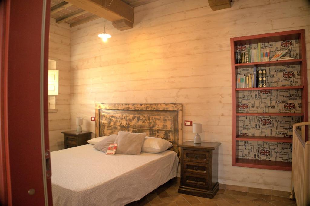 um quarto com uma cama e uma estante de livros em Agriturismo Santo Regolo - relax toscano ✺✺✺ em Torretta