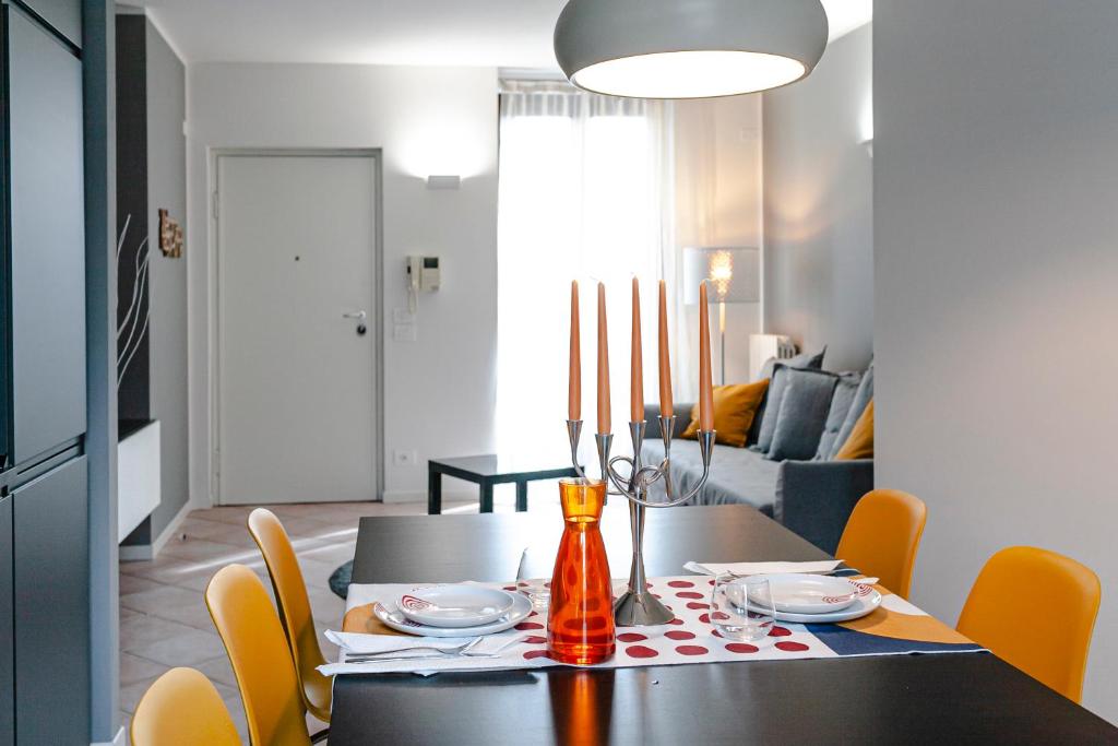 une salle à manger avec une table noire et des chaises jaunes dans l'établissement APARTMENTS VALPOLICELLA: RESIDENZA OLIVO, à Fumane