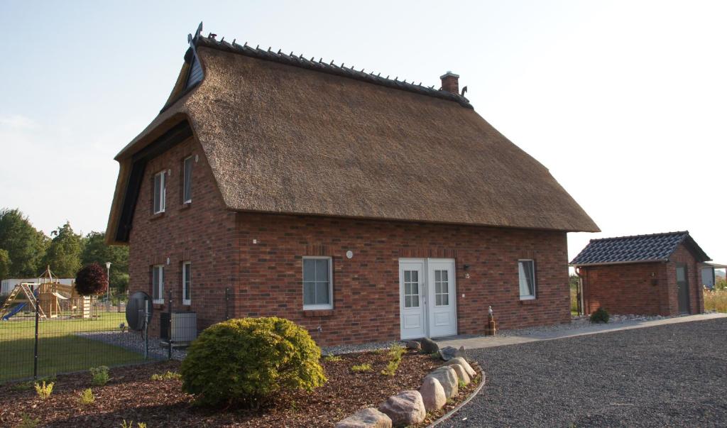 a large brick house with a thatched roof at Ferienhaus Auszeit an der Üselitzer Wiek in Mellnitz