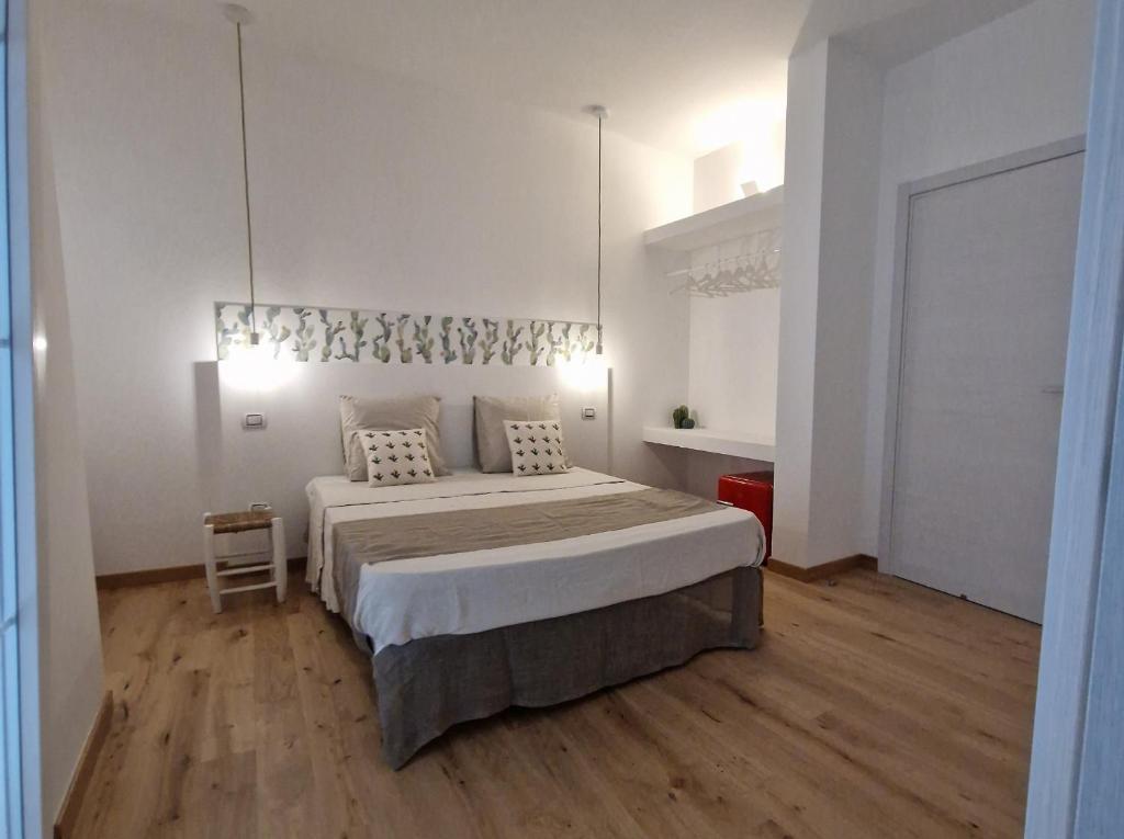 una camera da letto con un letto grande in una stanza bianca di Guest House Mela a Lecce