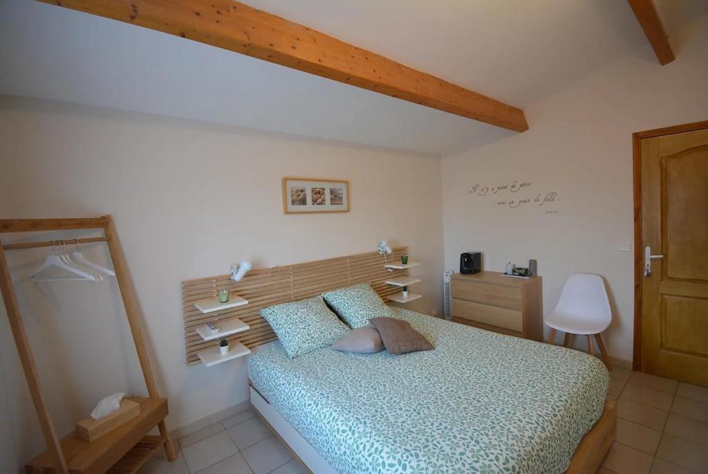 a bedroom with a bed with a wooden headboard at Au BeauLieu in Beaulieu