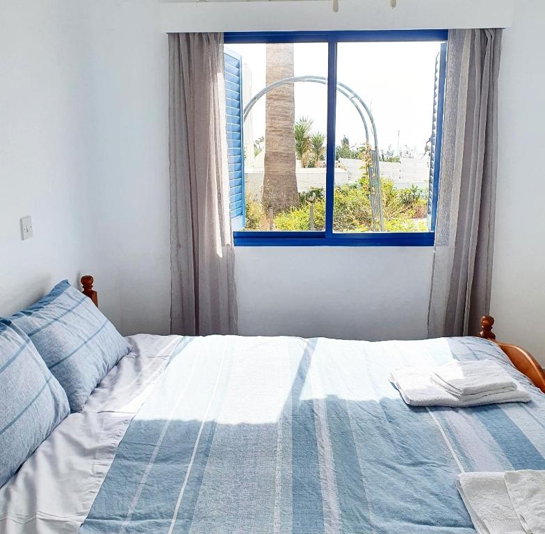1 dormitorio con 1 cama frente a una ventana en The SunSet 005, en Klorakas