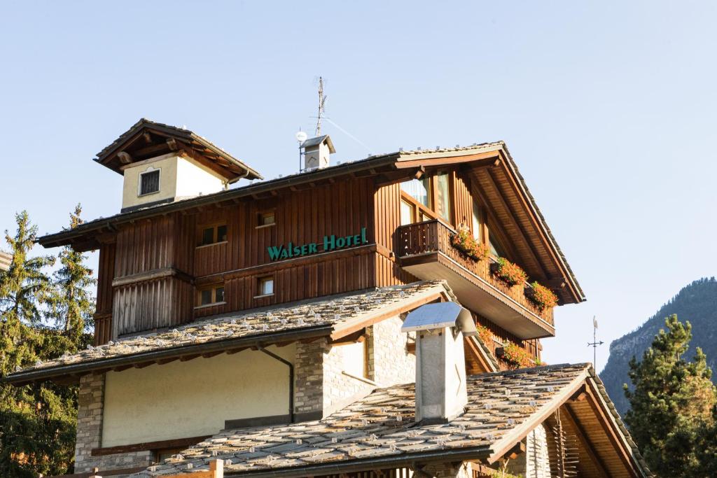 a building with a clock tower on top of it at Hotel Walser Courmayeur in Courmayeur