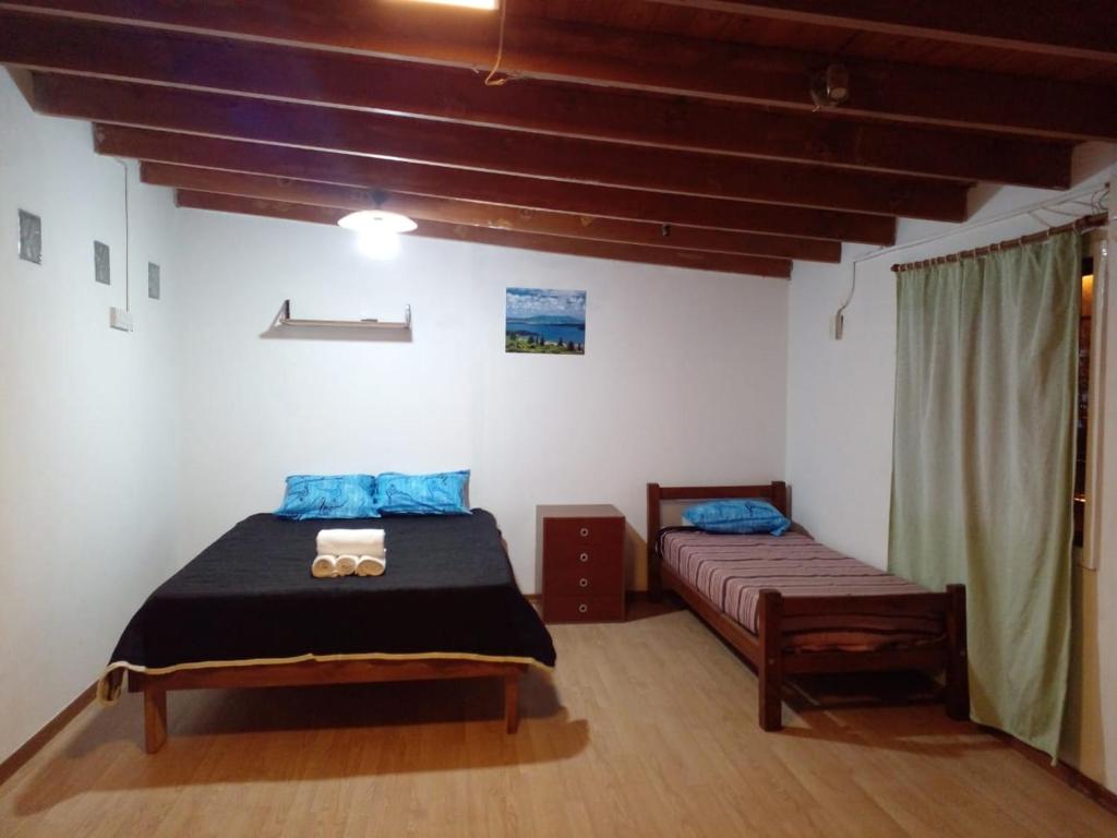 Un dormitorio con dos camas y una ventana. en Departamentos Sarmiento 3, en San Luis