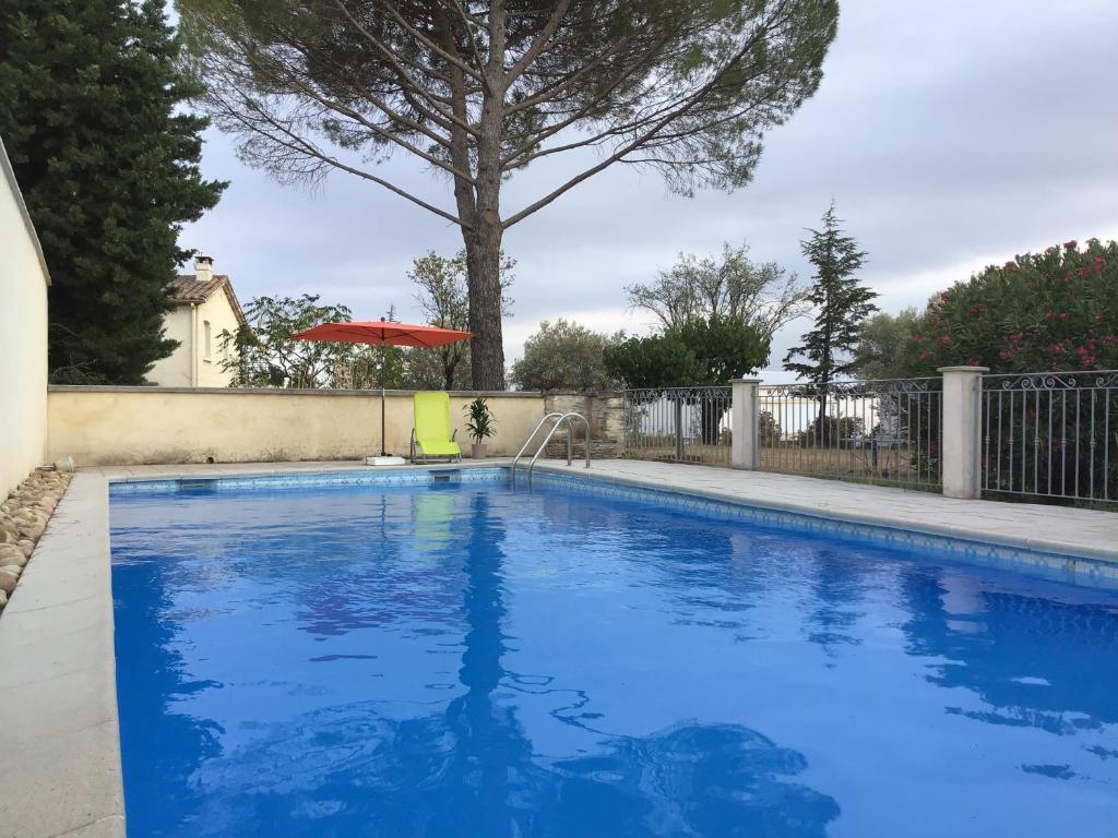 - une piscine dans une cour avec un arbre dans l'établissement Le Clau provençal, à Alès