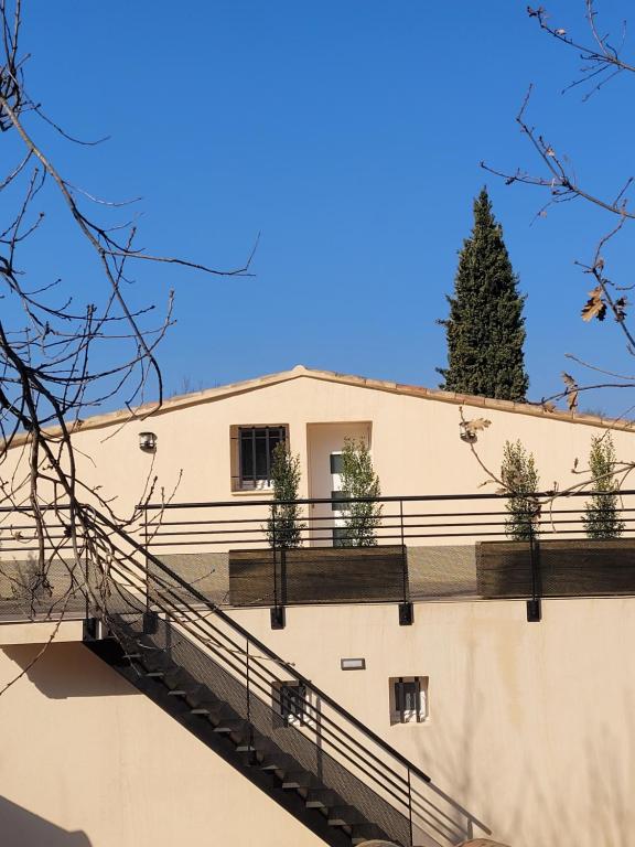 un bâtiment blanc avec un arbre en arrière-plan dans l'établissement Villa L'Abaguie-Charmant logement au calme entre mer et montagne, à Cagnes-sur-Mer