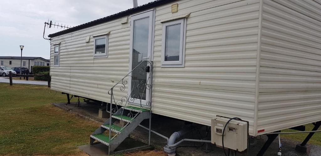 a large white trailer with a ladder next to it at The selsey retreat in Selsey