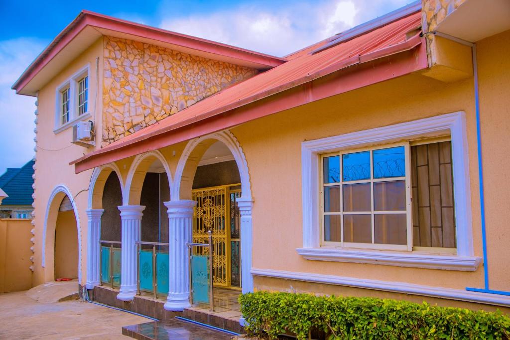 een kleurrijk huis met een rood dak bij BBD Hotel And Suites in Ibadan