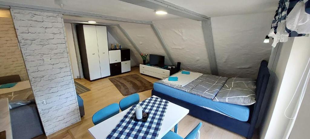 um pequeno quarto com uma cama, uma mesa e cadeiras em Słoneczny apartament em Duszniki Zdrój