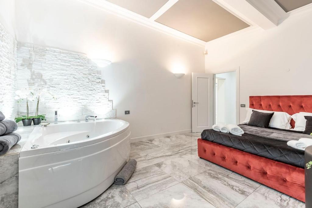 a white bathroom with a tub and a bed at Daphne Luxury Suites in Rome