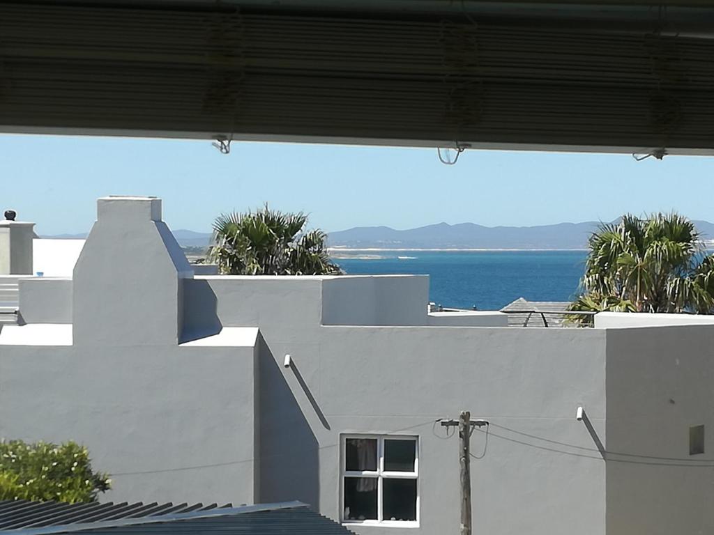 een uitzicht op de oceaan vanuit een wit gebouw bij Siesta in Hermanus