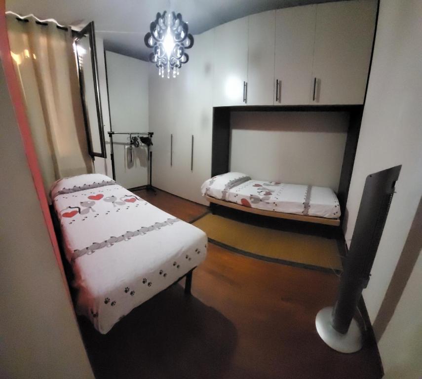 a room with two beds and a chandelier at Casa Cristina in Parma