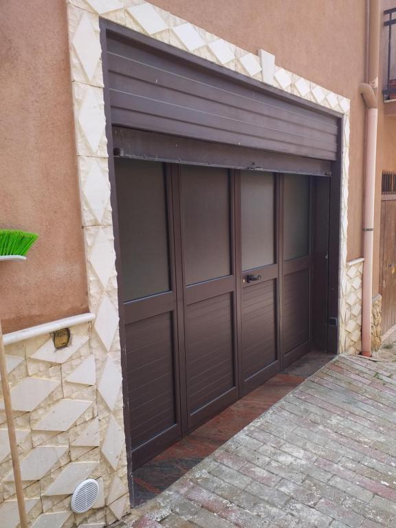 un garaje con una puerta de garaje marrón en un edificio en Appartamento piano terra, en Montallegro