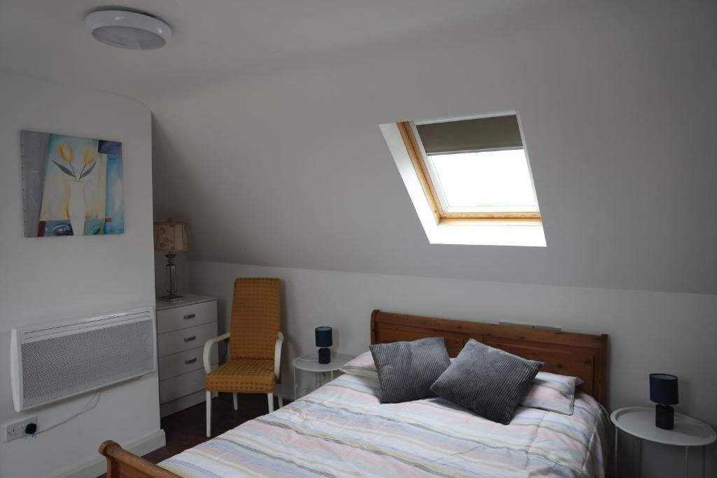 1 dormitorio con cama y ventana en Cosy Loft situated on shores of Lough Neagh 
