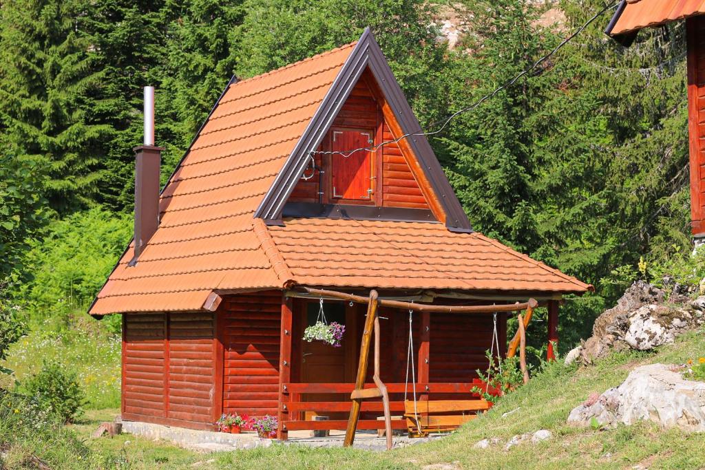 une petite cabine avec un toit orange et une fenêtre dans l'établissement Lodge Drveni Kutak, à Sekulić 