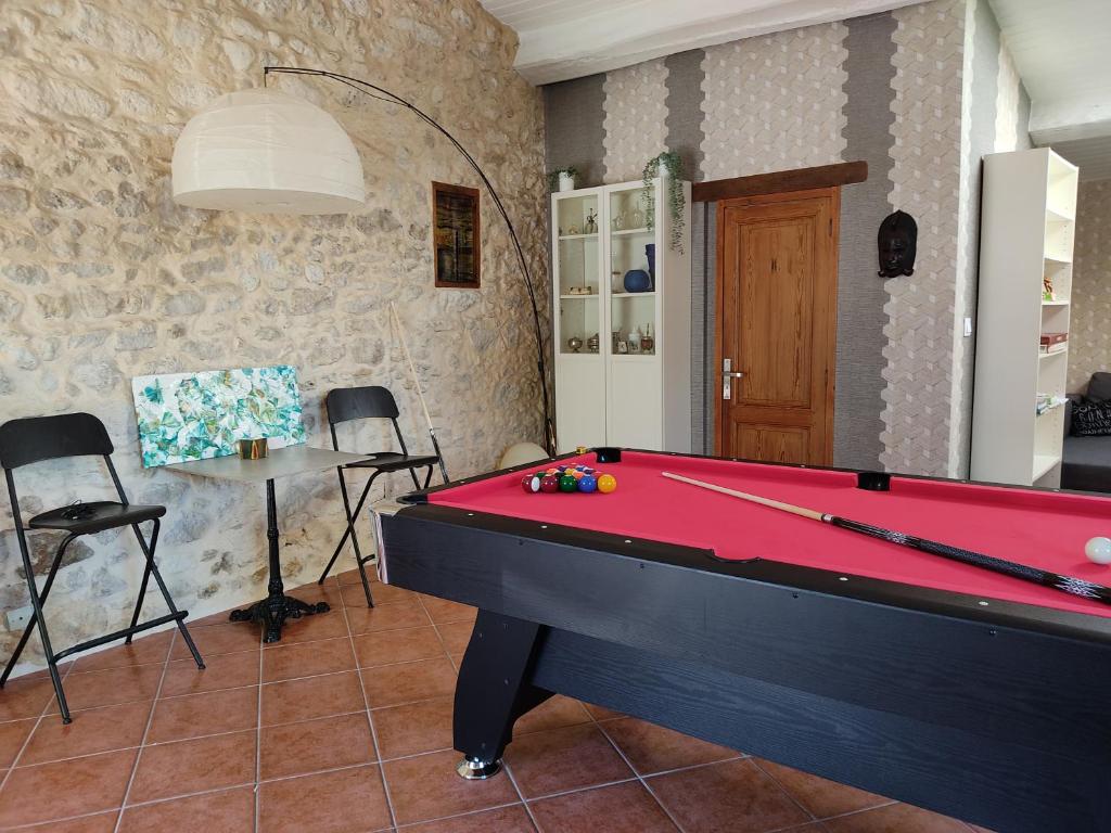 een pooltafel in een woonkamer met een tafel bij gîte du Laïka in Listrac-Médoc