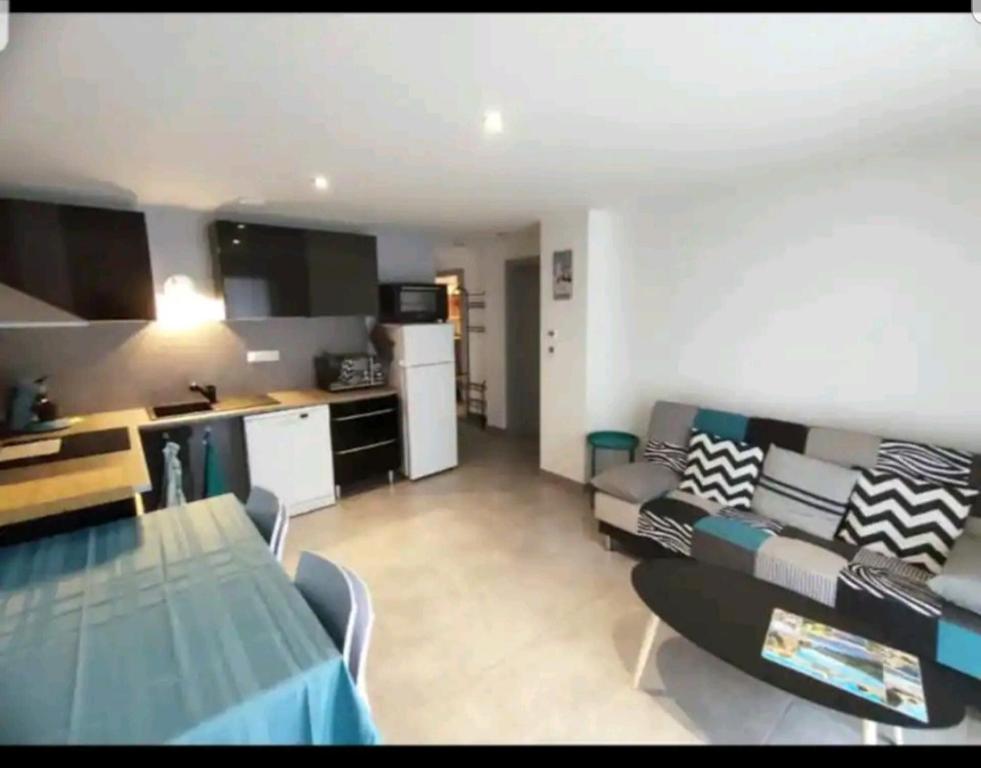 une cuisine et un salon avec un canapé et une table dans l'établissement Appartement moderne près du lac et centre ville. Résidence les Eaux Vives., à Gérardmer