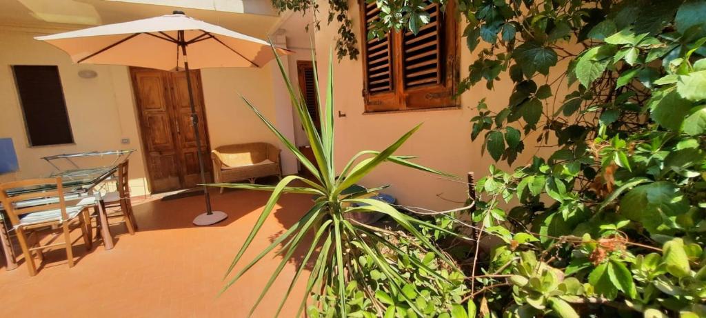 ein Zimmer mit einem Tisch, einem Regenschirm und Pflanzen in der Unterkunft Marchesana Terme - Holiday Home - Family in Terme Vigliatore