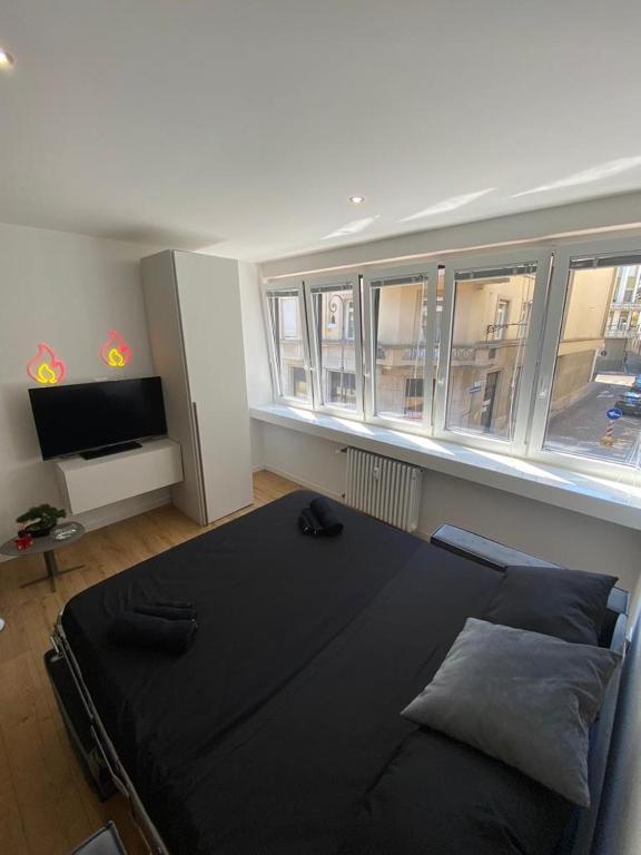duże czarne łóżko w pokoju z oknami w obiekcie [Udine Centro] Ade Apartment w mieście Udine